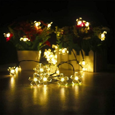 Guirlande exterieur lumineuse blanc chaud installée dans plante