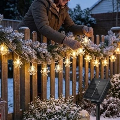 guirlande lumineuse extérieur installee sur cloture par femme